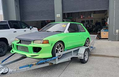 Car with green & black vehicle wrap